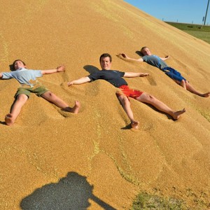 Comedian Rick Mercer playing in a pile of grain