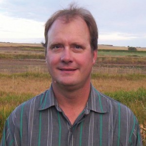 man standing in farm field