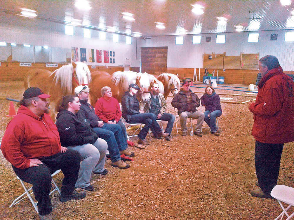 A group of veterans and their spouses debriefs during a Can Praxis course. The course uses equine therapy to help Canadian Forces veterans and families affected by PTSD.
