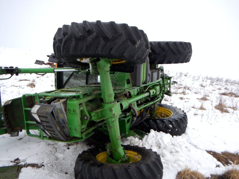 Damaged tractor laying on its side.