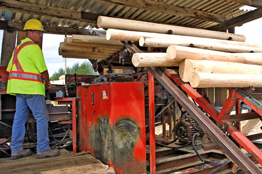 Worker handling logs in a sawmill