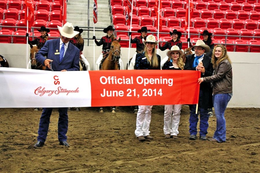 Stampede president Bob Thompson does the ribbon-cutting honours while Pete Fraser and Megan McLeod (on far right) look on.
