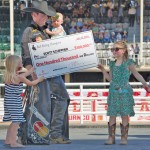 Six-year-old Maysa Schiffner and sister Hadley, four, help their dad with his big cheque while eight-month-old Oaklyn looks on.