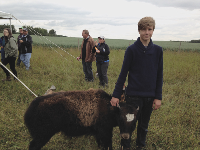 Drew Juuti, 15, stands with his bottle baby, EVangeline, a four-month-old yak. Evangeline is mostly yak, but has a little bit of cow in her as well.