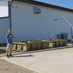 Larry Braul stands next to an above-ground biobed at a field
day in Outlook, Sask.