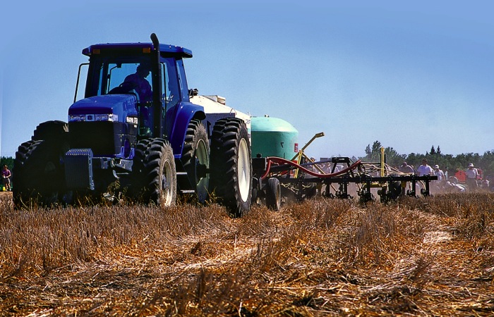 tractor spreading fertilizer in a field