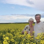 farm couple standing in canola field