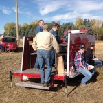 About 100 people — including longtime project members Jack Siebenga (left side of trailer), Ken Ditzler (middle in jean jacket), and Vic Bergen (right) — came out on Thanksgiving Saturday last October to help with the Central Alberta Growing Project harvest.