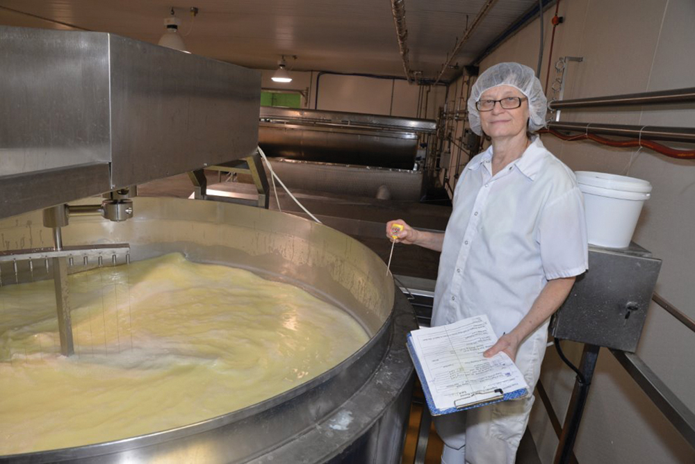woman making cheese in an urn
