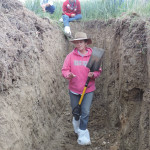 Renowned soil scientist Jill Clapperton climbs into a pit to show some features of soil, during a hands-on workshop on soil health.