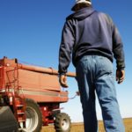 Farmer walking toward combine.