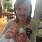 Megan Andrews holds an egg from one of four hens that she and her brother overwintered.