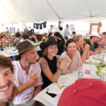 Bette Mitchell, wearing white, sits with family and friends at the Rootstock Fundraiser. Mitchell, her husband,
and four sons own and operate Flint Rock Ranch.