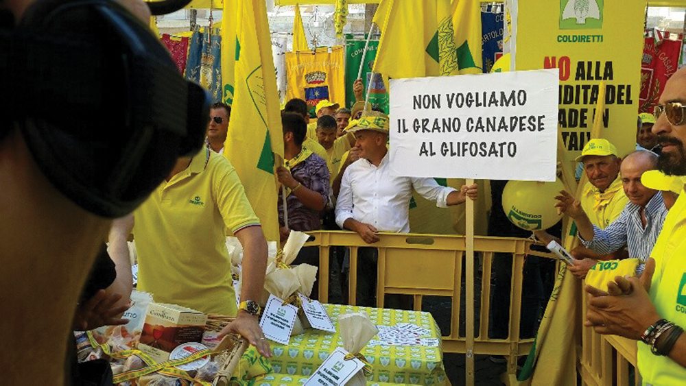 Farm group Coldiretti, which says it represents 1.6 million Italian farmers, attracts a lot of media attention with its demonstrations, including this one in Rome last summer. The message on the sign in a photo from an Italian TV station’s coverage of the demonstration translates as ‘We do not want the Canadian wheat that has glyphosate.’