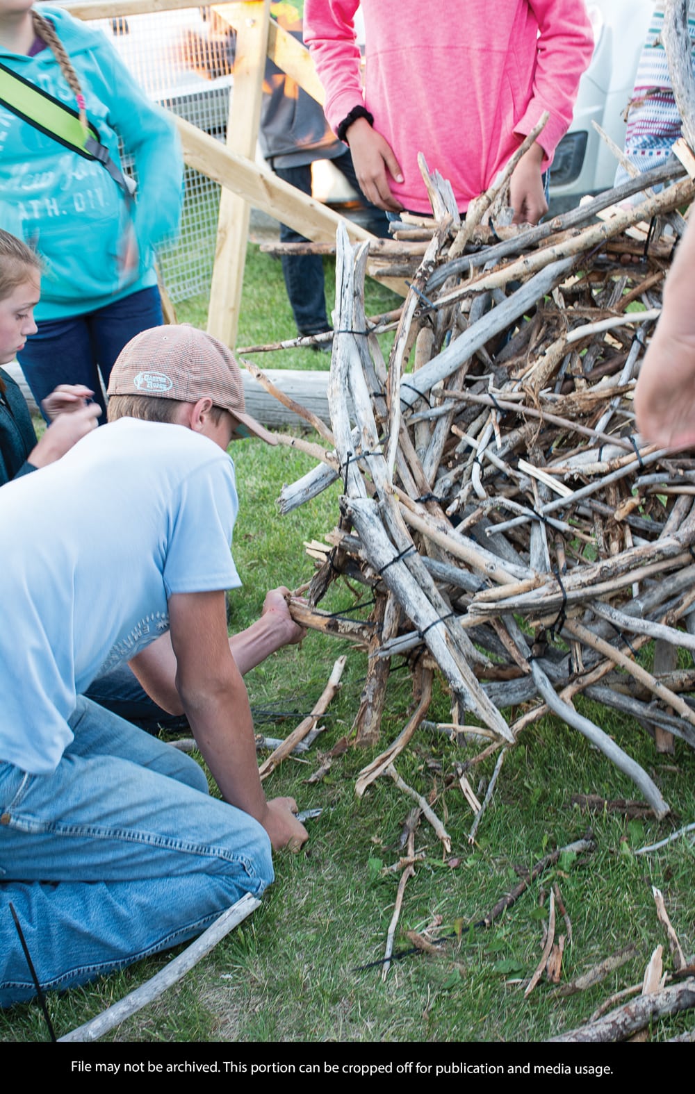 Youth volunteers constructing the ferruginous hawk nest on the ground for it to be later hoisted onto the platform.