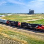 A CN train hauling grain cars circles the loop at GrainsConnect’s Maymont, Sask loop-track/power-on terminal. The locomotive never has to be detached from the train when loading or unloading, which cuts the time it spends at an elevator by up to half compared to conventional grain terminals.