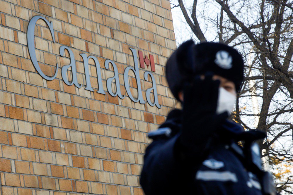 A police officer gestures at the photographer outside Canada’s embassy in Beijing on Dec. 12, 2018. (Photo: Reuters/Thomas Peter)
