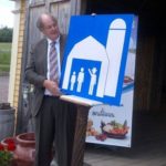 New Brunswick’s ag minister Michael Olscamp, shown here at Moncton in June last year launching new highway signage for agri-tourism sites, was among the provincial Tories defeated in Monday night’s election. (GNB.ca)
