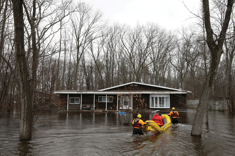 Officials check on a flooded home in the Constance Bay area in Ottawa on April 26. A grant of nearly $250,000 from the Intact Foundation for a quartet of flood mitigation projects was announced as communities in Ontario, Quebec, and New Brunswick were battling devastating floods.