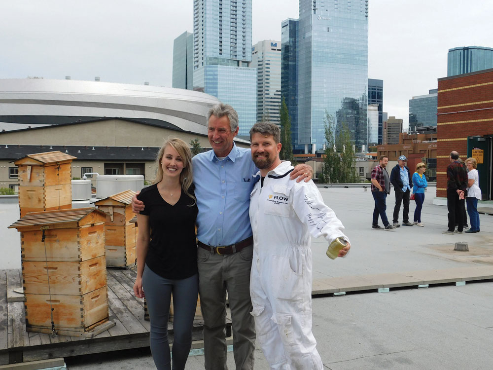 Flow Hive co-creator Stuart Anderson (flanked by MacEwan sustainability director Kalen Pilkington and beekeeper Troy Donovan) checks
out his creation on the roof of one of the university’s downtown buildings.