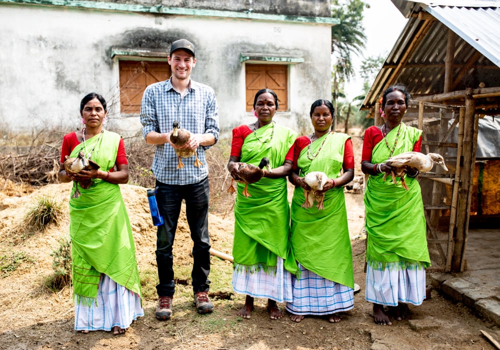 Colin Boender with a group of women who several years ago had a duck house built and were given eggs. Now the ducks and their eggs both supply their families and are sold, providing the families with a small but precious income stream.