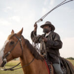 Once he swapped his baseball cap for a period cowboy hat and put on a fake beard, American rodeo champion Fred Whitfield became the “embodiment of John Ware.”
