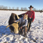 Etienne de Jongh (left) poses with a bottle-fed yak named Brutus and farmer Shane Juuti
at West Gimlet Farms during
his mini-internship in
the fall of 2019.