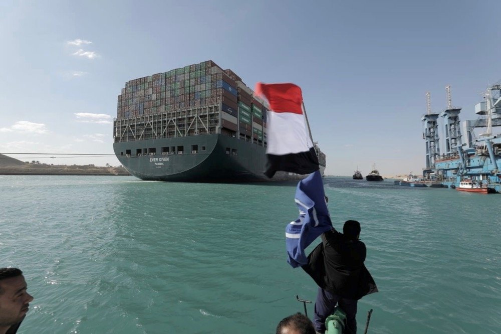 A man waves an Egyptian flag after the Ever Given, one of the world’s largest container ships, is fully floated on the Suez Canal in Egypt on March 29, 2021. (Photo: Suez Canal Authority handout via Reuters)
