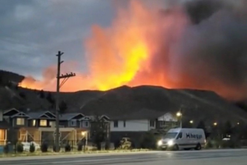 Smoke rises from a wildfire over a hill at Kamloops, B.C. on July 1, 2021, in this screen grab obtained from a social media video. (Nicole Ritter via Reuters)
