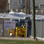 Security wear face masks at the Greeley, Colorado, JBS USA meat packing plant where two staff members had died of COVID-19, April 8, 2020. Photo: REUTERS/Jim Urquhart/File Photo