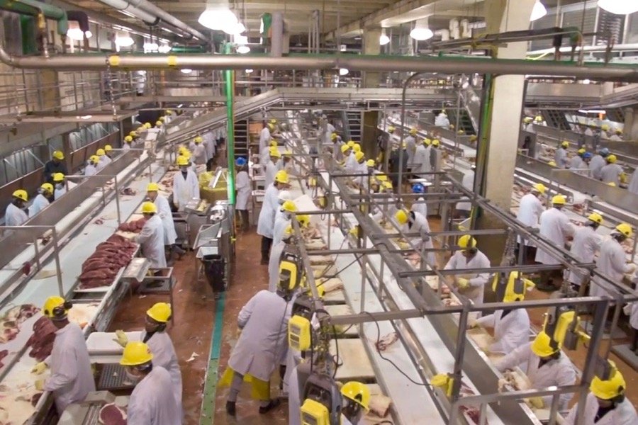 Workers in the JBS beef plant at Brooks, Alta. appear in a screen shot from a 2018 corporate video. (JBS Canada video screengrab via YouTube)
