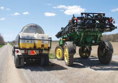A sprayer loads with a pesticide tank mix on the side of a road. 