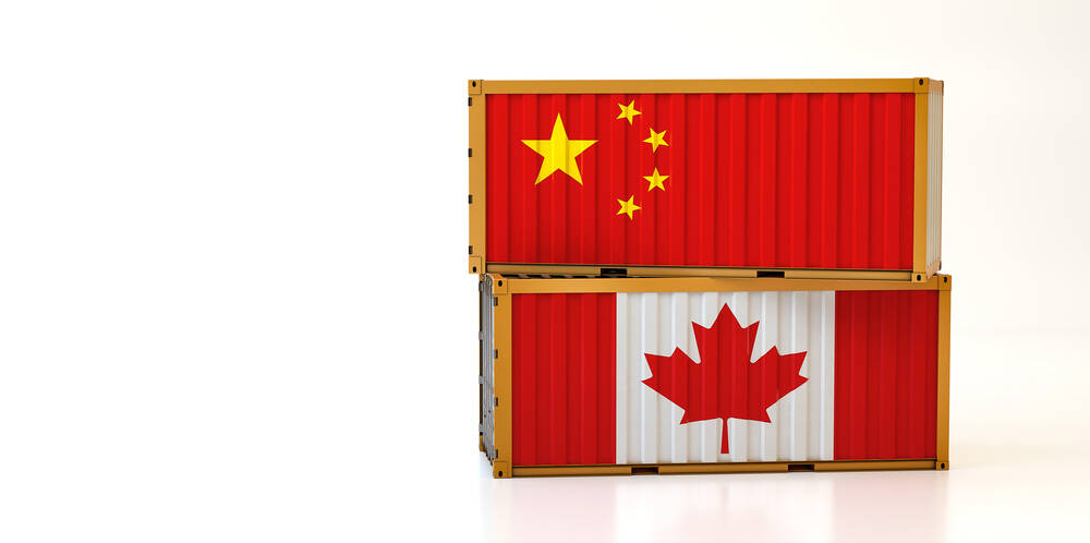 Two stacked shipping crates, the top one with a Chinese flag and the bottom with a Canadian flag.