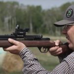 A man holding a dart gun.