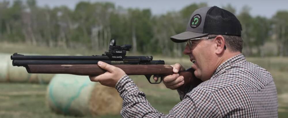 A man holding a dart gun.