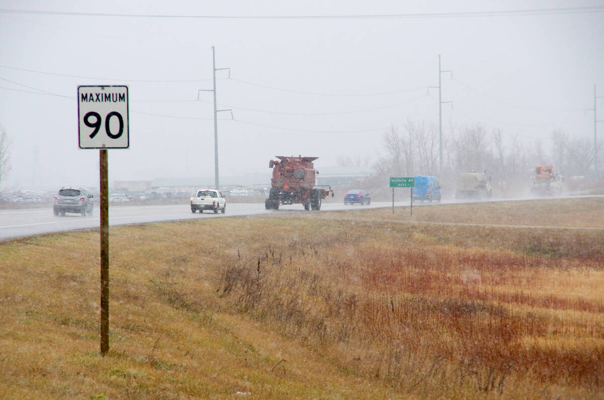 Urban traffic veers around a combine on a highway. Some survey respondents pointed to concern over urban development jutting up against land previously used for farming. Photo: File