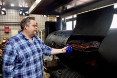 Charles de Pellette, Operations Director of the restaurant, poses for a picture next to U.S. beef and pork in a smokehouse, at Home Plate BBQ, an American-style restaurant, in Beijing, China April 17, 2025.  Photo: Reuters/Tiffany Le
