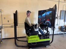 Karson Wasylciw, a student with Northwestern Polytechnic's agriculture operations program, drives a simulated tractor .