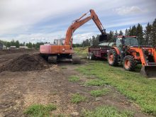 Ward Middleton -- an organic farmer located north of Edmonton -- mixes a row of compost with manure. He says any additional feedstock for composting or fertilizing is welcome.