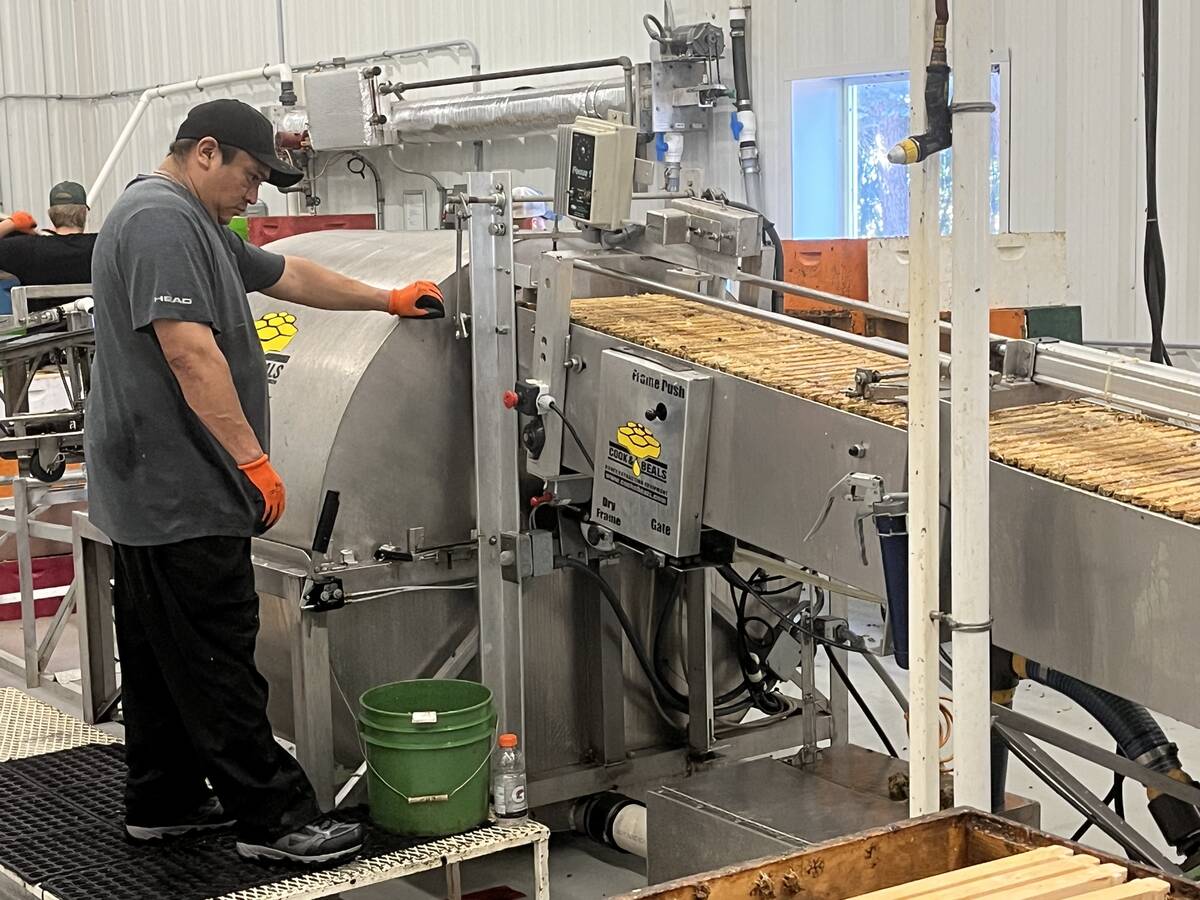 Honey is extracted from frames using a machine at Thrive Honey after they are heated in a room to make it flow easier for extraction. Photo by Greg Price