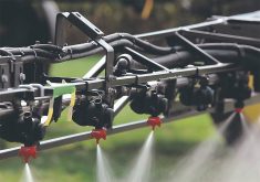 Nozzles along a sprayer boom apply farm chemical.