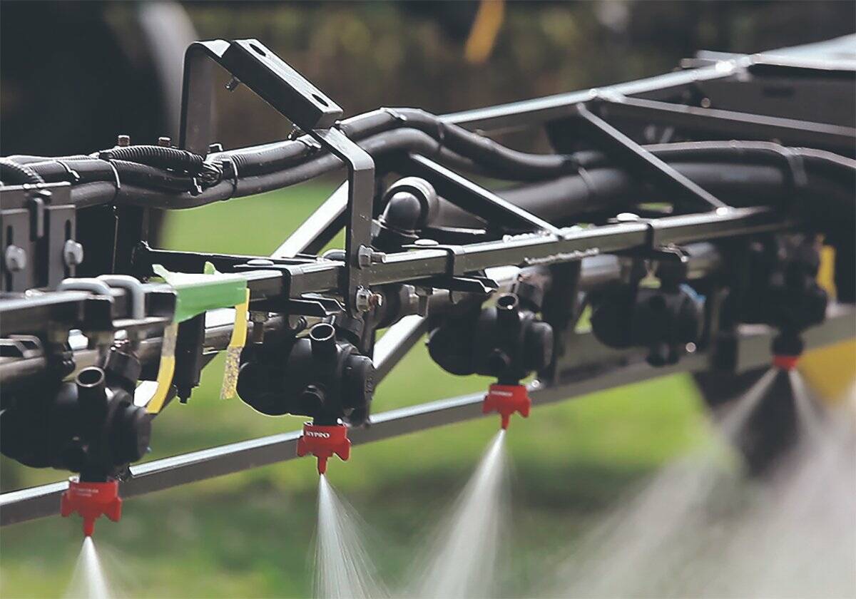 Nozzles along a sprayer boom apply farm chemical.
