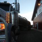 Dawn is breaking as the truck parks at its third dairy of the day, this one near Picture Butte, Alta.
