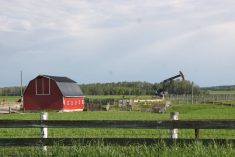 A pumpjack works beside a central Alberta farm pulling up oil to fuel the provincial economy