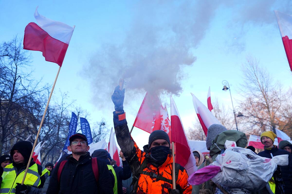 A demonstrator holds a flare as Polish farmers protest against the Mercosur trade deal in front of the Chancellery of the Prime Minister, in Warsaw, Poland, January 9, 2026. Photo: REUTERS/Aleksandra Szmigiel
