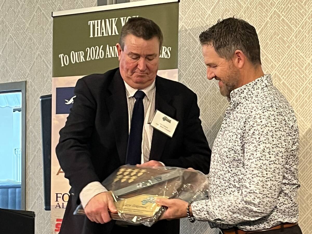 Gary Tokariuk (left) receives some gifts of appreciation for his six years of service as president of the Alberta Sugar Beet Growers, as he handed the reins over to Darren Klemen (right) at the organization’s AGM on Mar. 4 in Lethbridge, Alta.