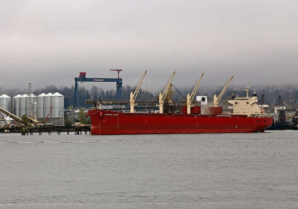Cargo ship in English Bay approaching Port of Vancouver grain terminals that depend on Second Narrows rail bridge for grain deliveries.