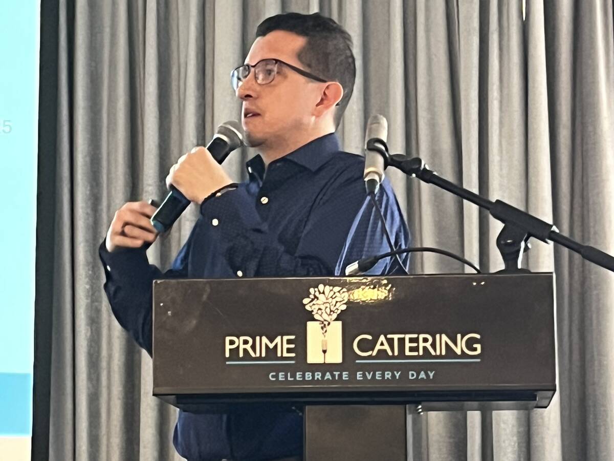 Javier Bahamon, Alberta Pork's quality assurance and production manager, speaks at a podium during a producer meeting in Lethbridge, Alta. Photo: Greg Price.