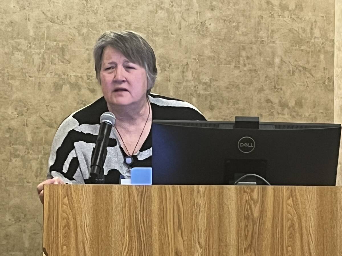 Kim Stanford speaking at a podium at the Alberta Beef Producers research showcase, where she presented findings on food waste as cattle feed. Photo: Greg Price.