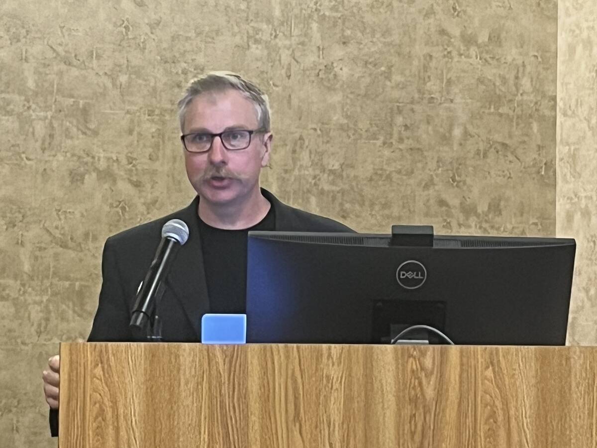 Dr. Rob Gruninger speaking at a podium with a microphone during the Alberta Beef Producers research showcase at the University of Lethbridge. Photo: Greg Price